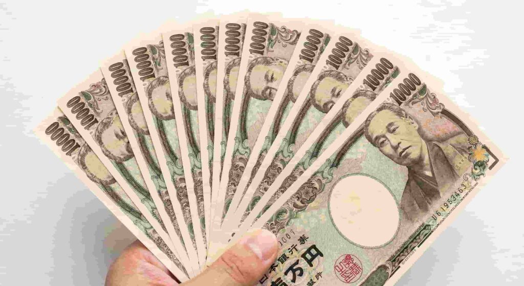 A close-up of a hand holding a fan of brand new, uncreased 10,000 Japanese yen notes.