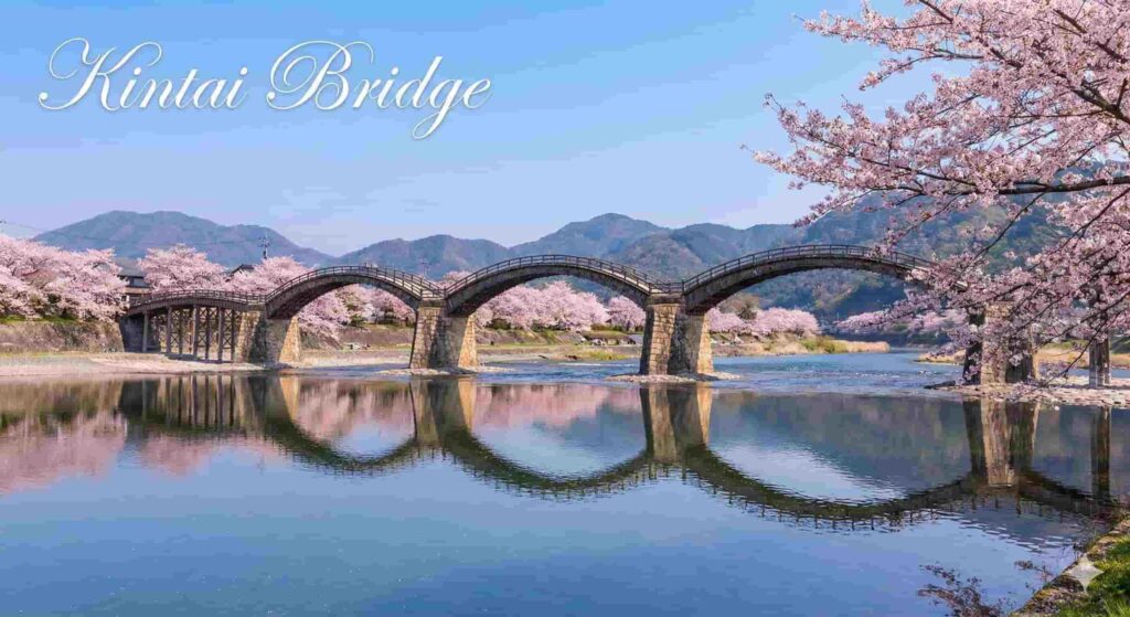 The five arches of Kintaikyo Bridge framed by cherry blossoms along the river.