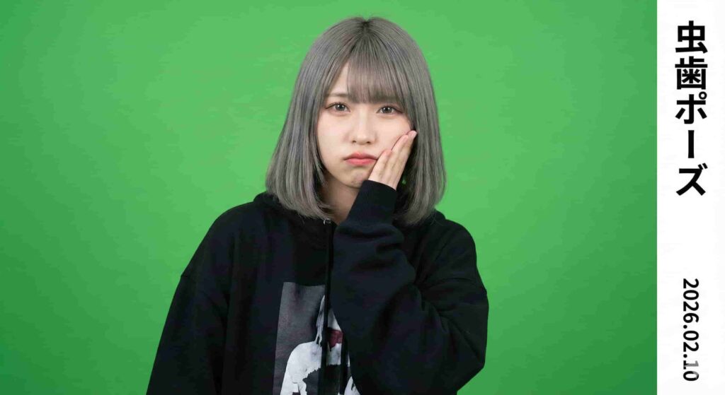 A woman with grey bobbed hair in a black hoodie holds her hand to her cheek with a pained expression, illustrating the "cavity pose" in a photo booth image.