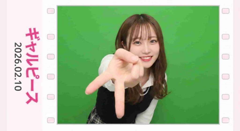 A woman smiles and makes an inverted "gyaru peace" sign toward the camera inside a film strip border with Japanese text "ギャルピース".